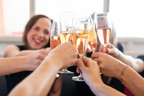 Menschen stoßen mit Sektgläsern bei Feier an