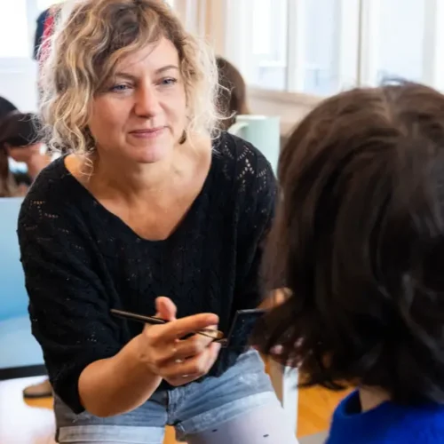 Visagistin schminkt Person im Studio