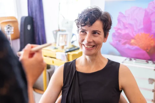 Glückliche Frau im schwarzen Kleid in kreativem Raum