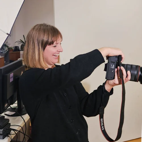 Lächelnde Frau fotografiert mit einer Kamera